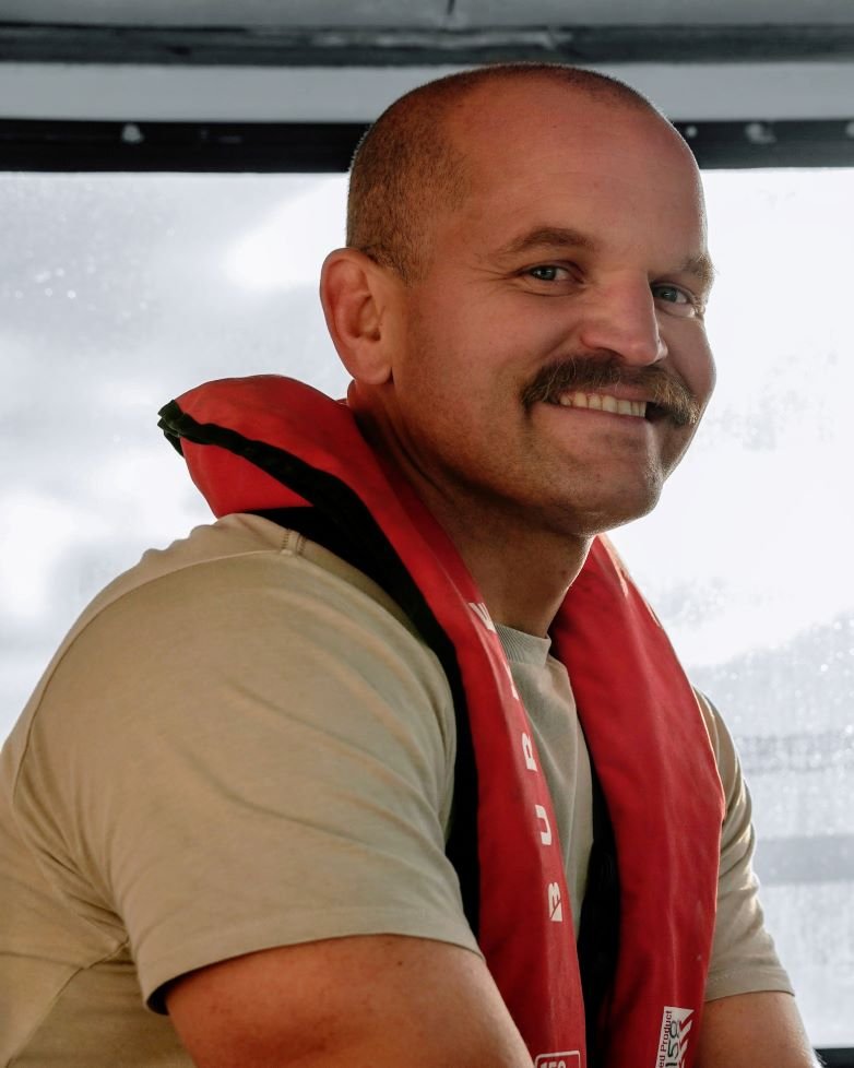 Barrett Wolfe in a red lifejacket in a boat cabin